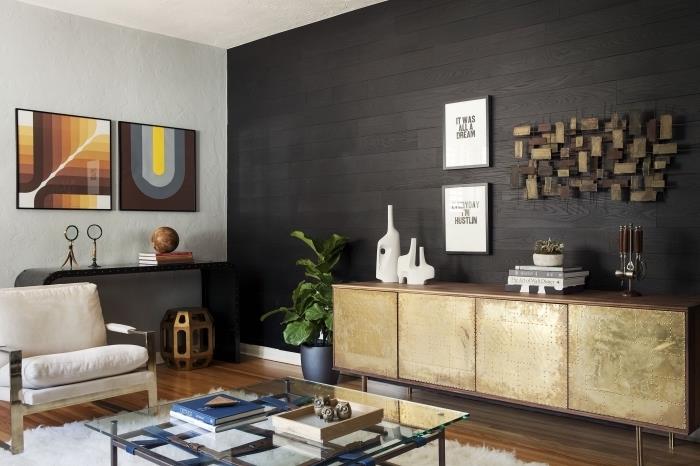 aprenkite sieną juodos medienos plokštėmis, svetainės išdėstymą lakuotomis medinėmis grindimis ir baldus su metaline apdaila