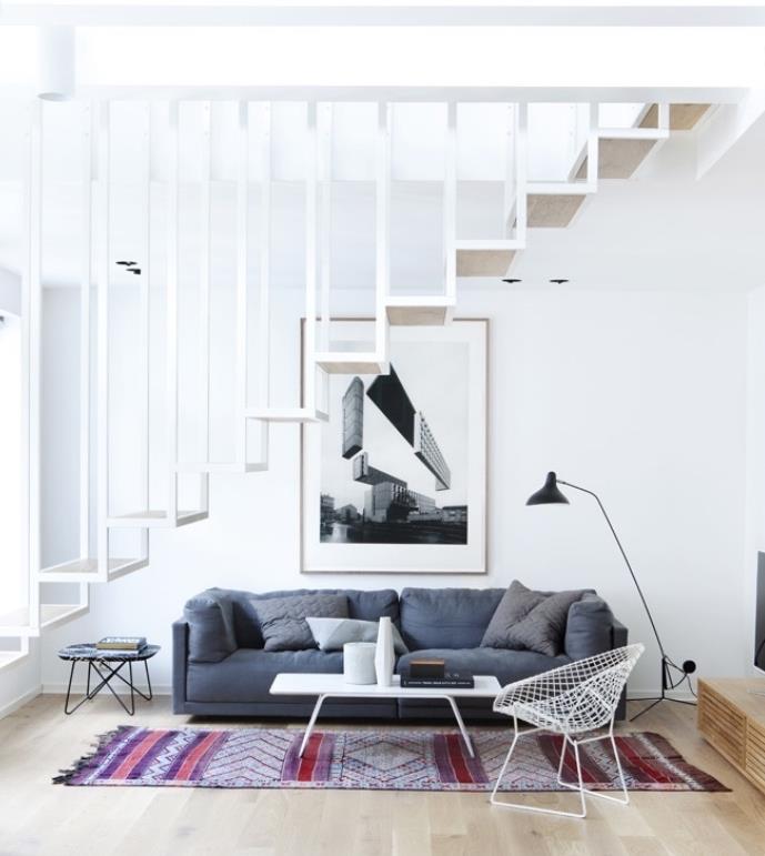 Gri kanepe ve oryantal halı, beyaz sehpa, metal sandalye, beyaz tasarım merdiven ile İskandinav oturma odası fikri