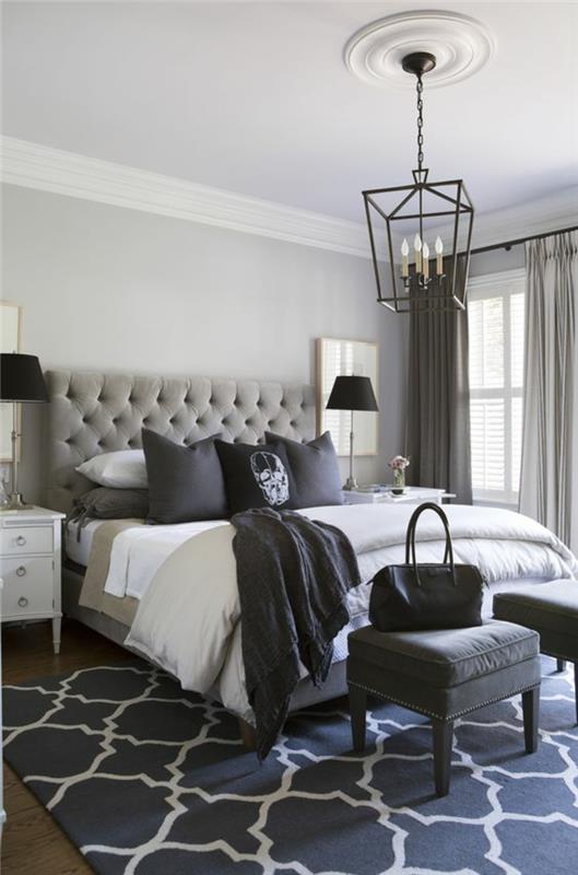 baroko baldai iš kaltinės geležies liustra ant lovos su didele atlošu, apmušta šviesiai pilka spalva