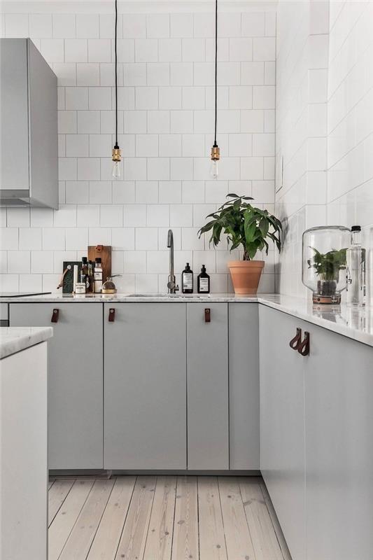şık bir mutfak için ne renk, deri kulplu dolaplarla donatılmış ve modaya uygun beyaz fayanslarla kişiselleştirilmiş İskandinav tarzı bir mutfak için tasarım fikri