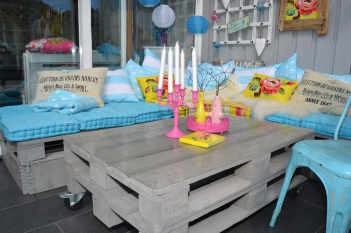 padėklų kėdė, padėklų suoliukas, padėklų sodo baldai, pastelinis mėlynas čiužinys, rožinė žvakidė baroko stiliaus su baltomis žvakėmis ant stalo