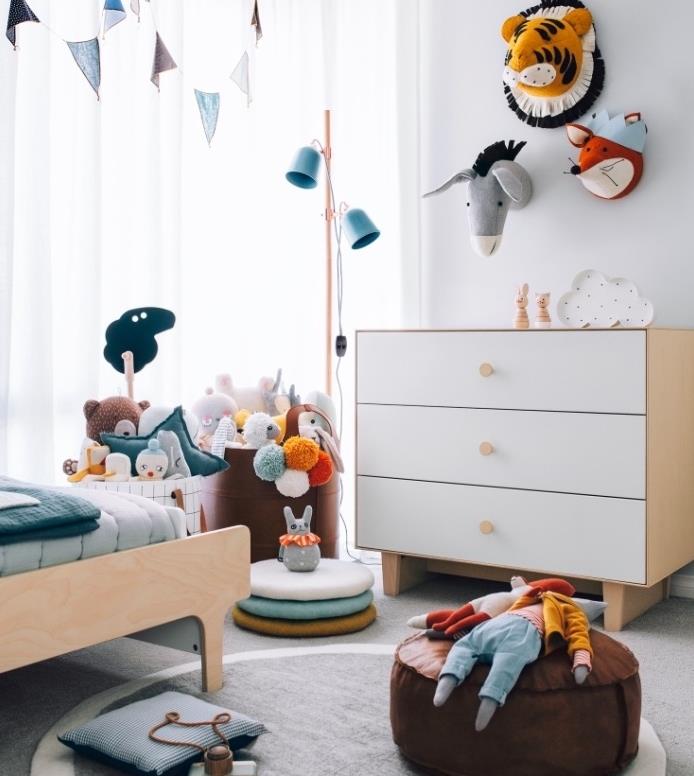 çocuk odası iskandinav mobilyaları, ahşap yatak ve şifonyer, gri halı, kahverengi puf, çantalarda saklanan oyuncaklar, hayvan duvar dekorasyonu