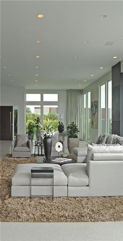 skandinaviški baldai-rūmai-skandinaviško dizaino baldai-smėlio spalvos kilimas-pilka-sofa-svetainėje