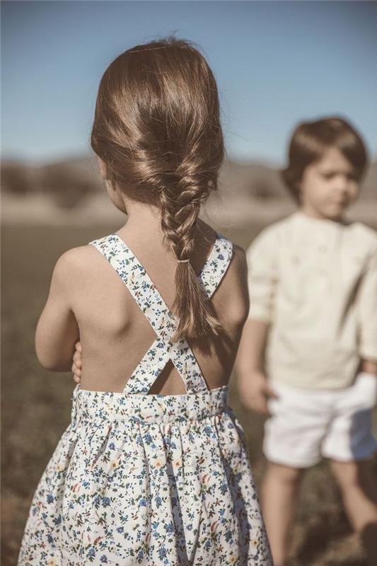 Merginos paprasta pynimo šukuosena, žavinga gėlių suknelė, berniukas ir mergaitė žaidžia kartu, vaikiška šukuosena, šukuosenos pynimas, kaip formuoti plaukus