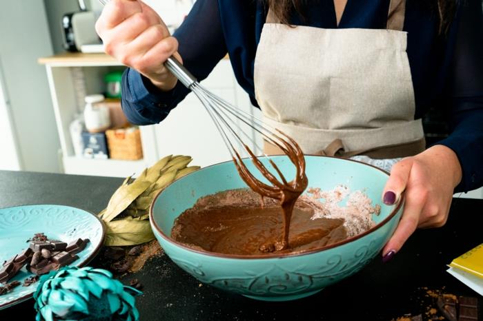 pienas ir kiaušiniai, įmaišyti į kakavą ir miltus, sumaišyti mėlyname keramikiniame dubenyje, šokoladiniai pyragaičiai