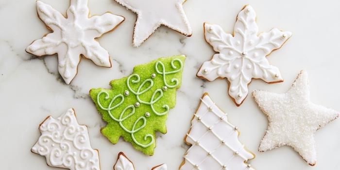 Alzaški model bredele s snežno dekoracijo s kraljevsko glazuro in sladkorjem v prahu, ideja božični piškotek z zelenim sladkorjem