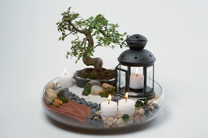 notranja dekoracija z vrtom japonskega tipa v okrogli stekleni posodi s prodnatimi svečami in bonsajem
