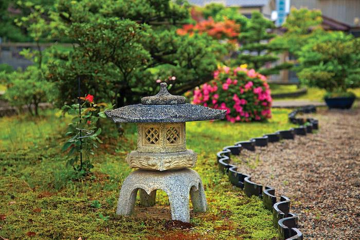 Ideja deco zenskega vrta v japonskem slogu z majhnimi drevesi in majhnim kamnitim templjem