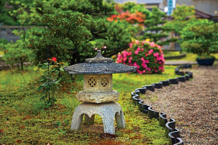 Ideja deco zenskega vrta v japonskem slogu z majhnimi drevesi in majhnim kamnitim templjem