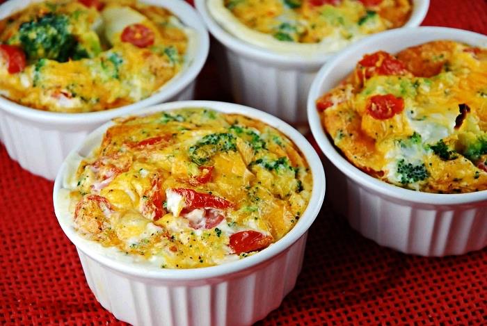 idėja pusryčiams, kuriuose gausu baltymų, ramekinai su kiaušiniais, brokoliai, pomidorai ir raudonieji pipirai, lengvas mini kišas su daržovėmis