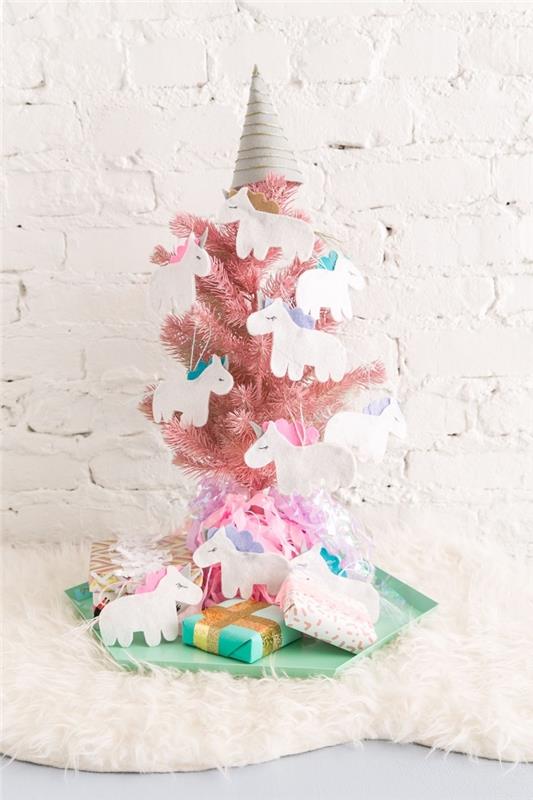 sıradışı Noel ağacı dekorasyonu, tek boynuzlu at kağıt süspansiyonlarla süslenmiş, nane yeşili su bazlı bir tepsiye yerleştirilmiş küçük pembe yapay ağaç