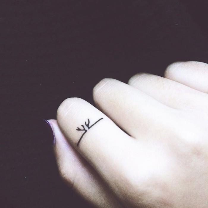 mažo piršto tatuiruotė ant bevardžio piršto kaip elnio ragų žiedas, diskrečios tatuiruotės modelio ir vietos pasirinkimas