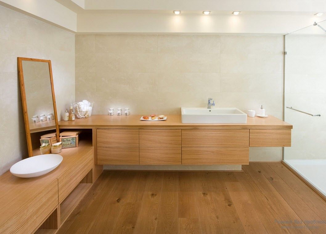 Espelho em moldura de madeira em harmonia com móveis de madeira e acabamentos de banheiro