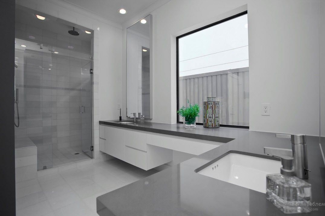 Interior do banheiro em cinza e branco com um toque brilhante na forma de uma flor