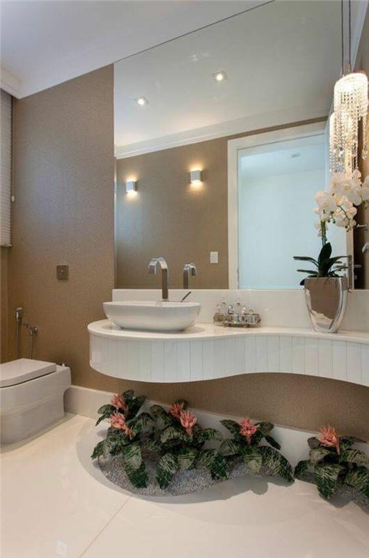 Dalgalı lavabo alanı ile duvarın çoğunu kaplayan ışıklı banyo aynaları