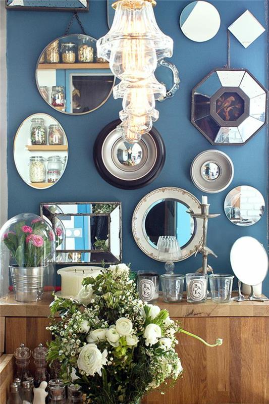 raganos veidrodis visą sieną su visų dydžių ir formų veidrodžiais su moderniais krištolo šviestuvais