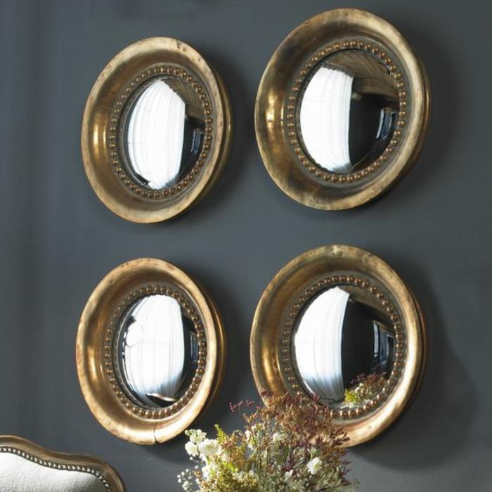 keturi elementai raganos akies veidrodis ant dūminės pilkos sienos, kad gražiai atspindėtų pro langus sklindančią šviesą