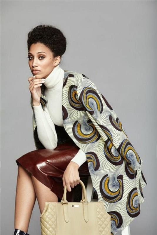 eleganten oblačilni slog, afriško rjavo usnjeno krilo, afriška moda, pulover z želvjim vratom v beli barvi, jakna tipa plašča z okroglimi okrasnimi aplikacijami v rjavi, črni in rumeni barvi