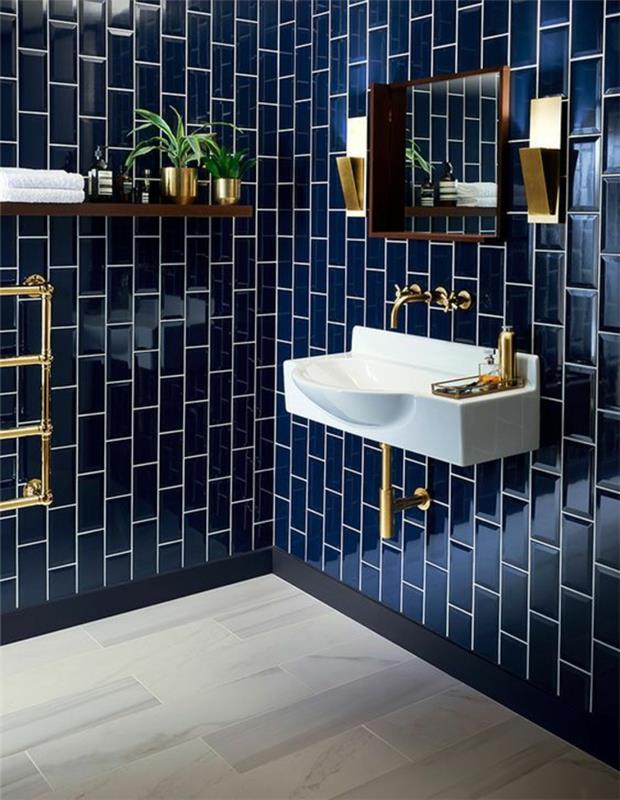 Zen kopalniški dekor, kopalnica 5m2, mornarsko modre ploščice z vzorci opeke, elegantno vzdušje, pravokoten bel umivalnik, ogledalo z zlatim okvirjem