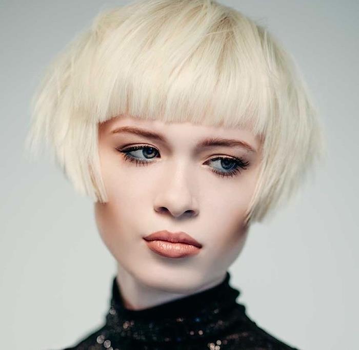 kratka frizura s šiškami in nagibom na laseh s polarno blond barvo, glamurozna ličila
