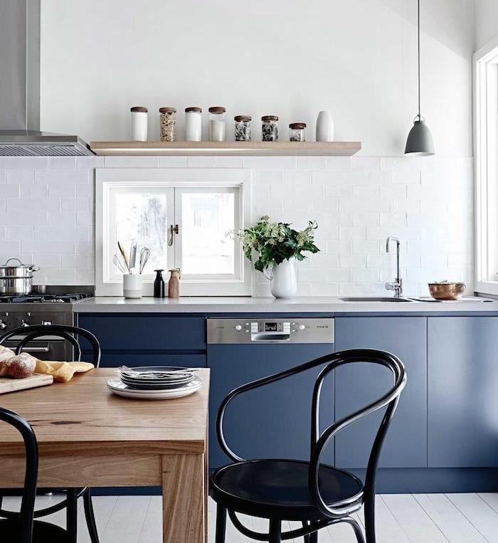 Beyaz kiremitli sıçrama, ahşap raf, yemek odası açılış ahşap masa ve siyah metal sandalyeler ile gece mavisi düşük mutfak dolabı