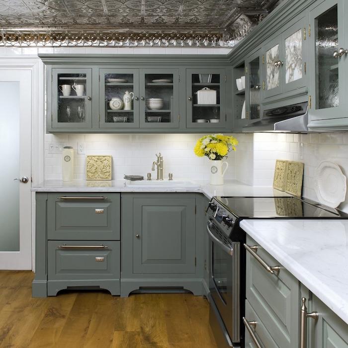 retro pilka virtuvė, žaliai pilki virtuvės baldai su balta plytelių siena
