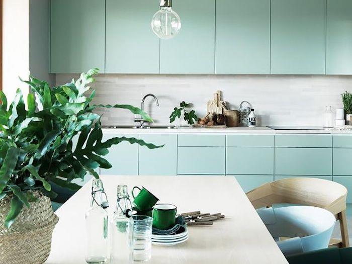 Ideja za fasado kuhinje v modri barvi Celadon, siva barva, marmorna delovna miza, umazano bela miza, bež, modri in zeleni stoli, listi zelenih rastlin v košarici