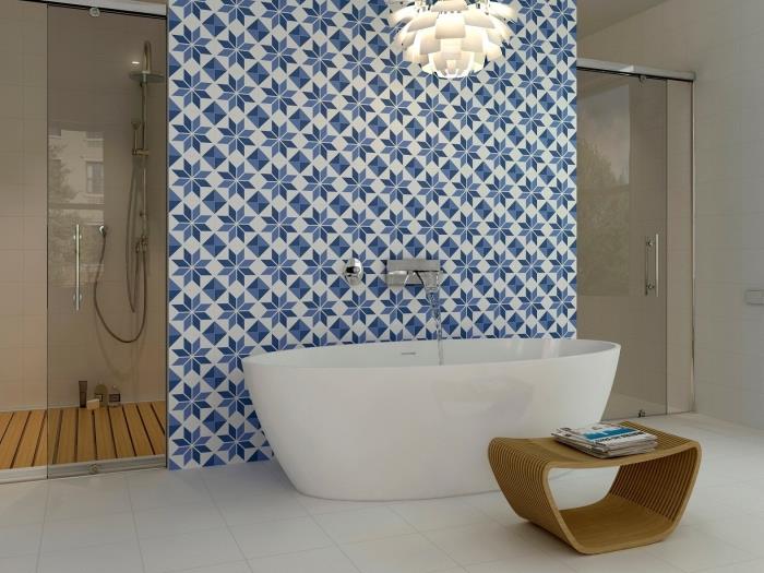 vonios vonios cementinės plytelės, uždėtos už vonios, kurios pažadina rafinuotą atmosferą savo retro mėlynos spalvos ramunėlių raštais