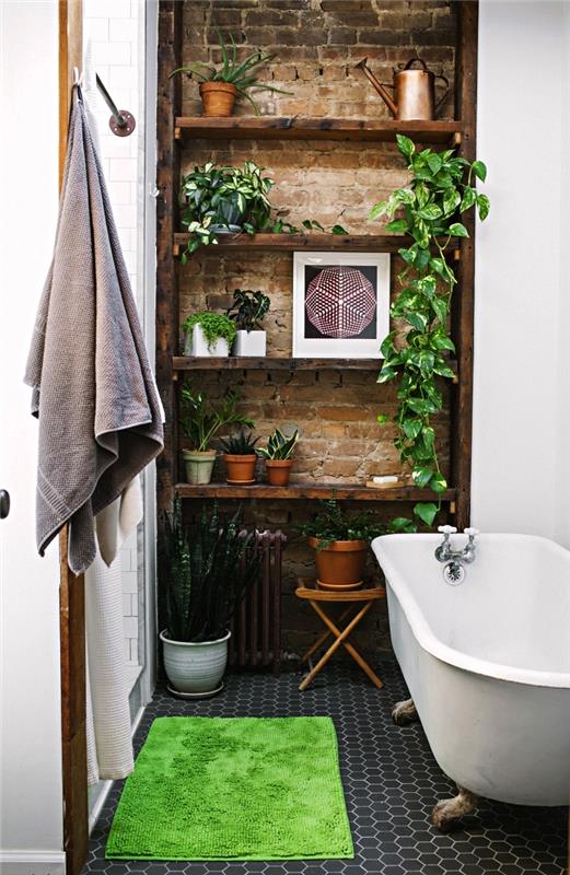 majhna kopalnica s starinsko kadjo in dekorjem zelenih rastlin, stena iz opeke z odprtimi policami z boemskimi elegantnimi poudarki