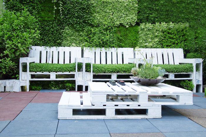 çim kaplı palet kanepe, yığılmış beyaz palet sehpa, dış yeşil duvar ile palet bahçe mobilyası modeli