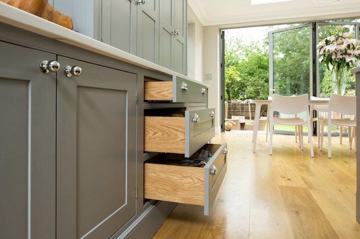 pilka atviros virtuvės spintelė su medinėmis laminato grindimis