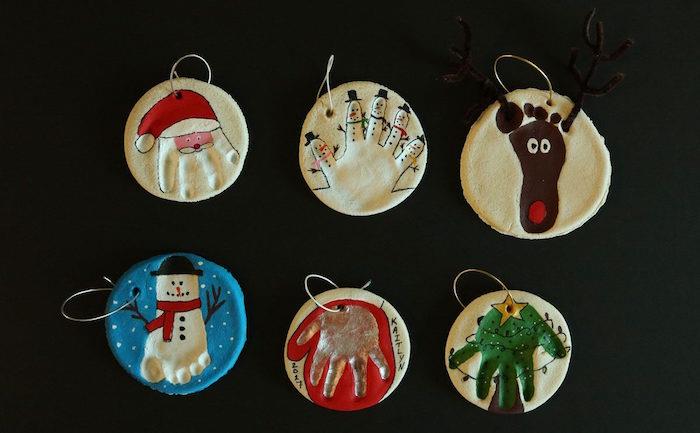bebeğin el izi ve boyalı Noel sembolleri ile küçük yuvarlak tuzluk süsler