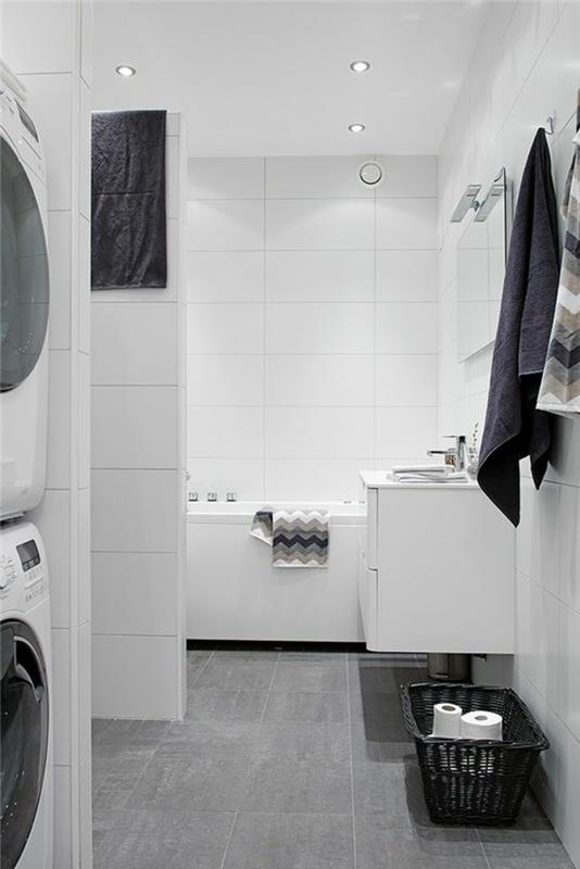 mažas vonios kambarys su baltomis sienomis ir pilkomis plytelėmis