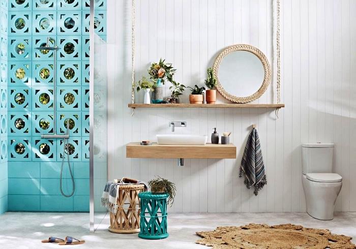 Maroška dekoracija kopalnice v beli in temno modri barvi, z italijansko prho, omejeno s stekleno steno, leseno umivalnico, usklajeno z visečo polico