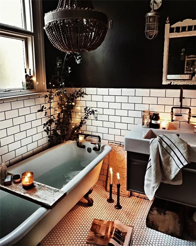 bela in črna kopalnica s starinsko kadjo, okrašeno s svečami in majhnimi sproščujočimi okrasnimi predmeti