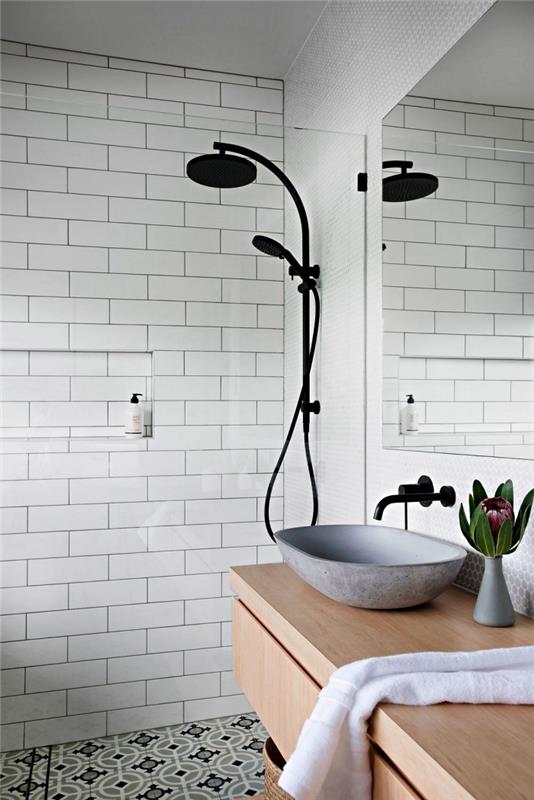 sodobna kopalnica z elegantnim skandinavskim dizajnom z mat črnim tuš kabinom in umivalnikom iz cementne plošče, cementne ploščice na tleh za vintage eleganten pridih v kopalnici