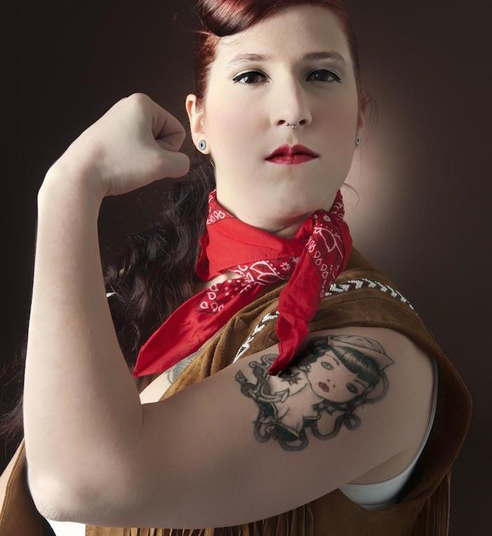 Model tetovaže pin-up na ženski roki v 50. letih z rdečo bandano okoli vratu in šminko