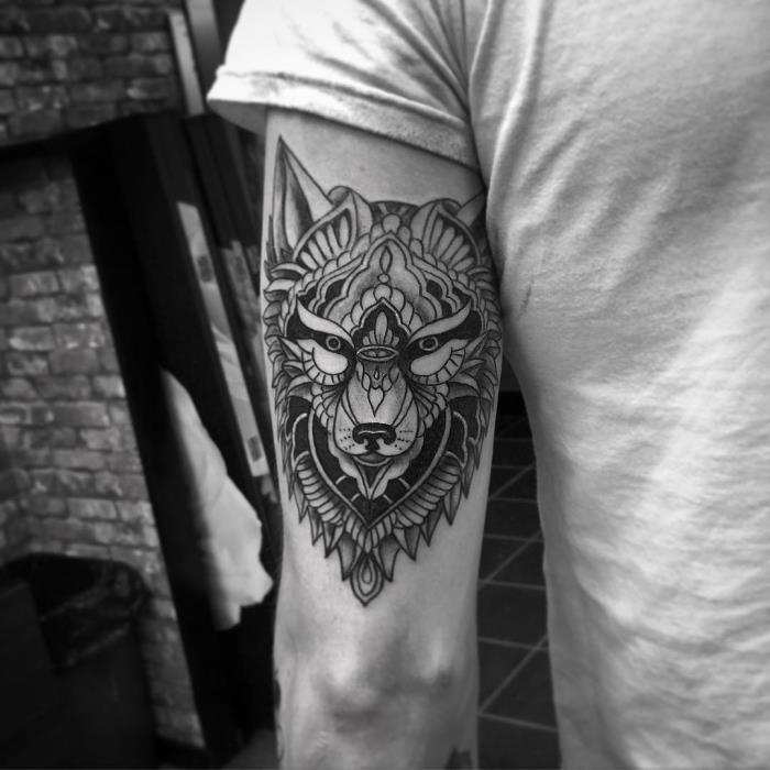 moška tetovaža, body art s črnilom na roki z vzorcem volka z etničnimi motivi
