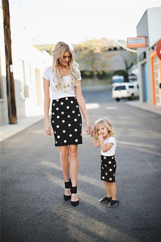 Balti marškinėliai su auksine etikete ir vidutinio ilgio taškuotu sijonu, motinos ir dukters apranga, kurie atrodo panašūs, kaip apsirengti 2 metų gimtadieniui