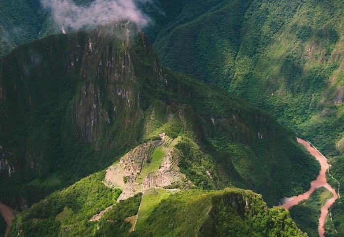 vaizdas iš paukščio skrydžio virš didingų kalnų, saulės spinduliai ir šešėliai virš kalvų
