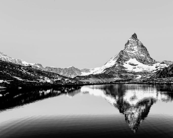 čudovita črno -bela podoba visokega vrha, ki se odraža v ledenih vodah jezera, najlepše enobarvne pokrajinske fotografije
