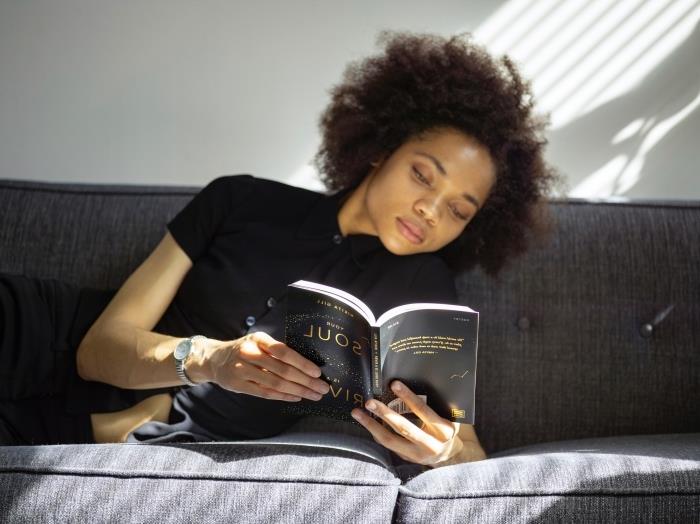 srebrna ura total look črna ženska oblačila udobna črna bluza frizura s kratkimi rokavi kratki vijolični lasje počitek branje knjige kavč dnevna soba