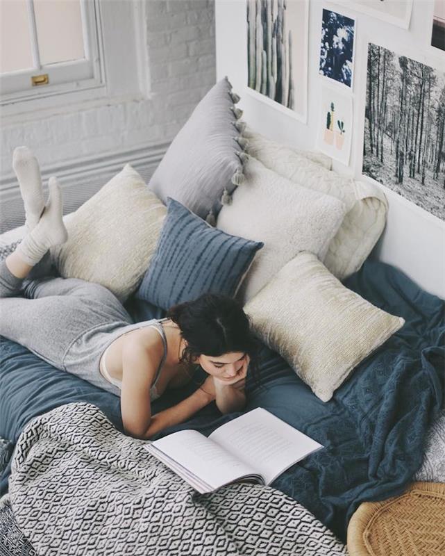 kokonuojanti lova su galvūgaliu su meniškais nespalvotais vaizdais, pilka ir balta patalynė, juodai balta lovos užtiesalas, balta plytų siena