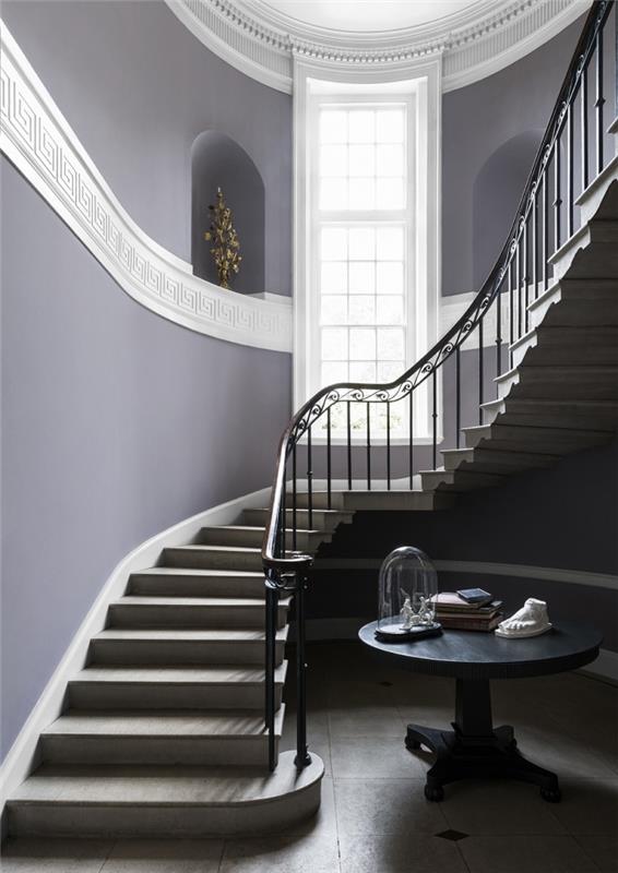 prostorno in elegantno stopnišče z vijoličnimi stenami z zidnimi nišami iste barve in belim frizom, ki prečka steno