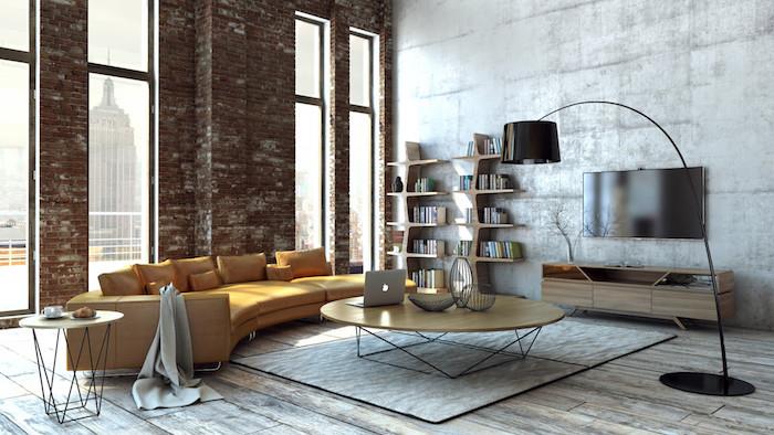 industrijsko pohištvo, opečna stena in betonska stena, lesena TV omarica, lesena in kovinska klubska mizica, obrabljen parket, rjav rumen kavč