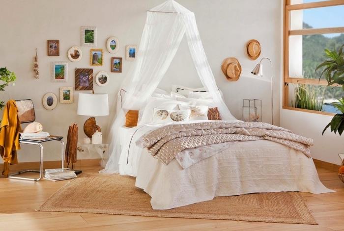 šiuolaikiškas bohemiškas prašmatnus miegamojo modelis su baltomis sienomis su šviesiu parketu, sienų dekoravimo pavyzdys su įvairių dydžių ir spalvų paveikslų rėmeliais