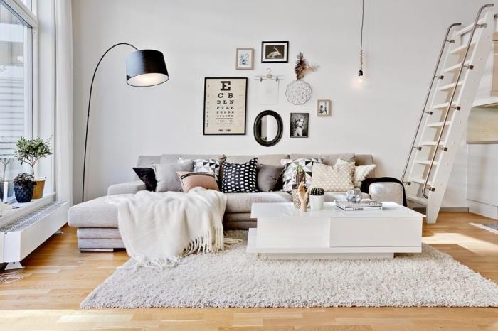 Skandinaviško stiliaus „cocooning hygge deco“ interjeras, nedidelė jauki svetainė su didele minkšta sofa ir šviesiu parketu, kuris suteikia šviesos