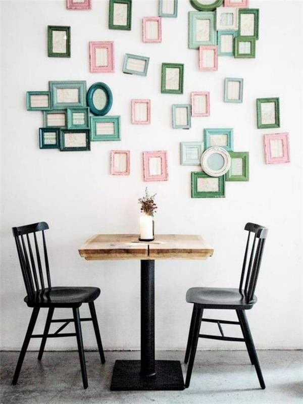 kovinski stoli in miza iz lesa in kovine, dekoracija živega okvirja, stena okrašena z več majhnimi zelenimi, modrimi in roza foto okvirji, voskano betonsko tla