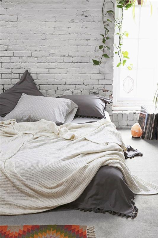 İskandinav yatak odası düzeni, beyaz tuğla duvar, tuz mumluk, asılı saksı, gri ve beyaz yatak