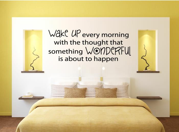 sarı ve beyaz yetişkin yatak odası, yatağın üzerinde güzel mesajlı yazıt, aydınlatmalı iki yan niş, yatak için sarı örtü, duvar bölümü, tasarım duvar dekorasyonu